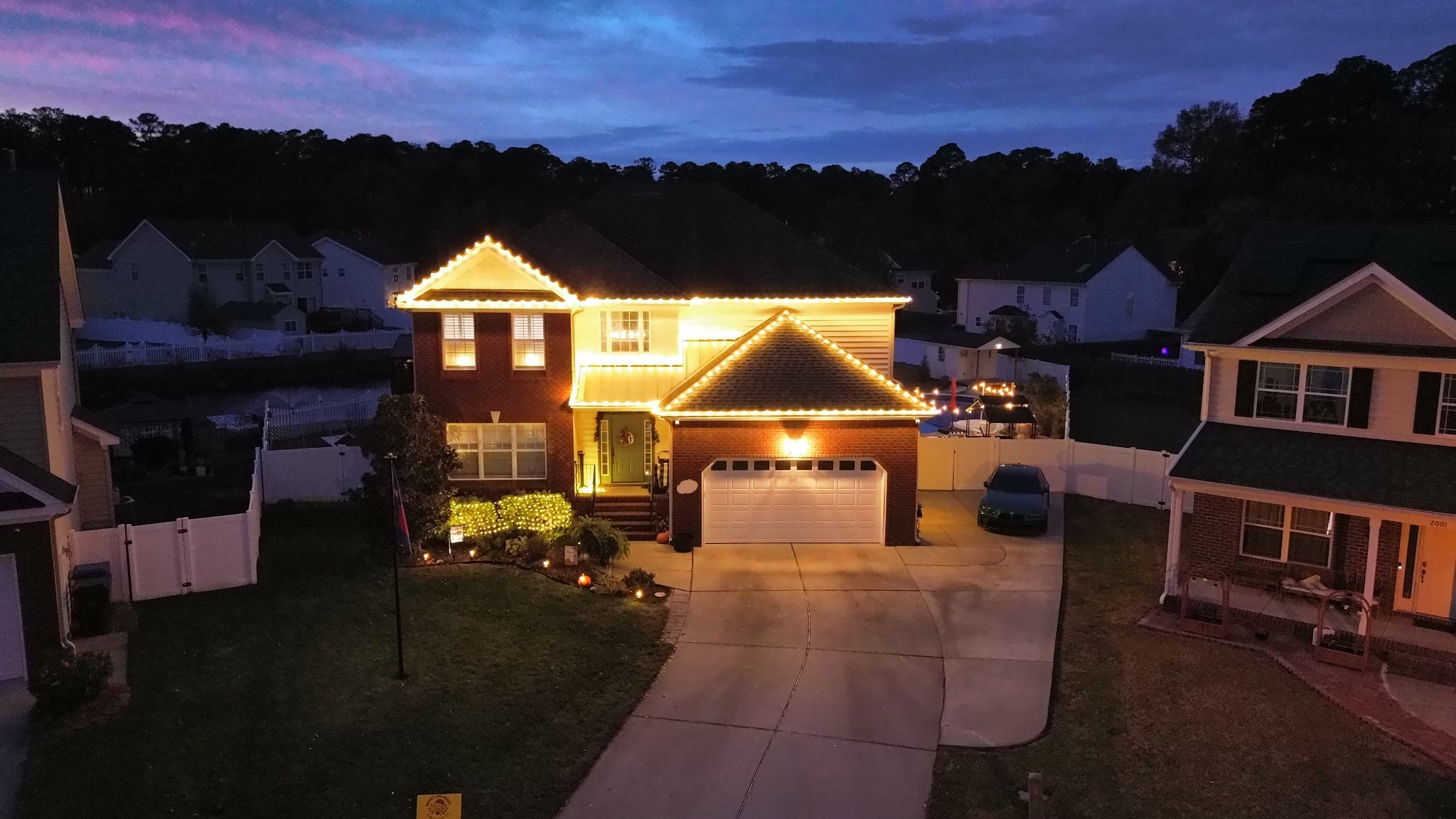Warm white Christmas roofline lights on a two-story home