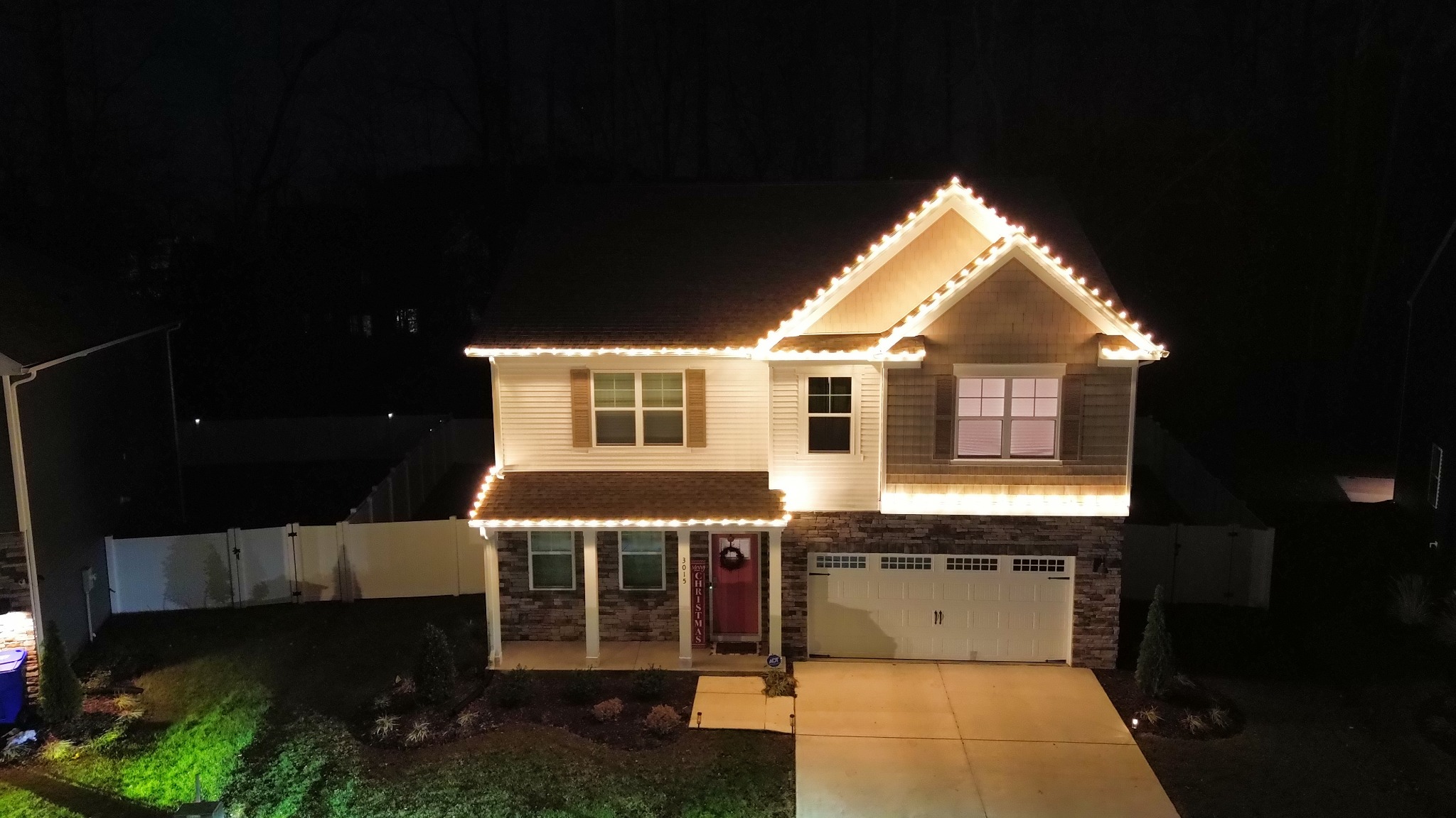 Warm white roofline Christmas lights on a two-story home